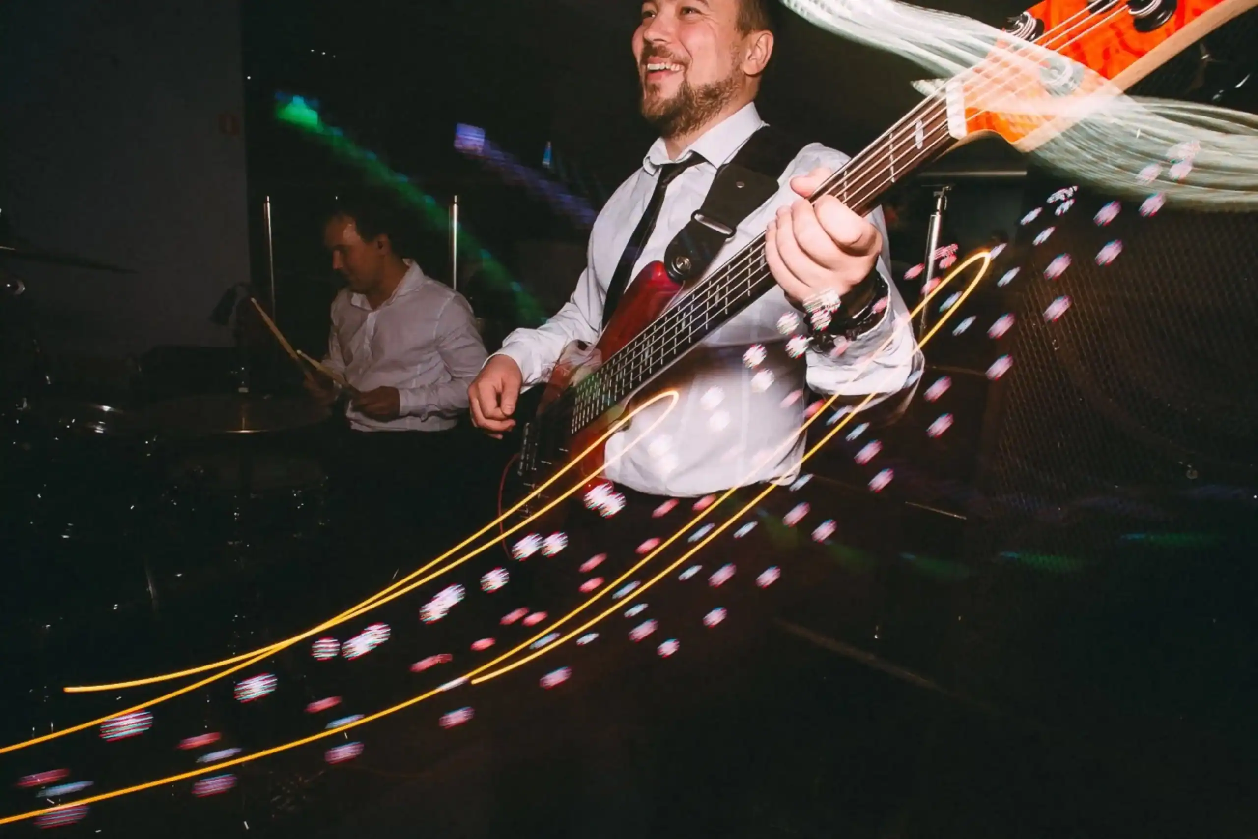 Man playing a bass guitar at a live event.